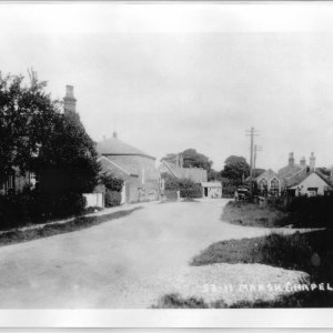 View down Sea Dyke Way, Marshchapel from Eskham end of the village.
The old Bakery can be seen behind the trees on the left of the photograph.
Further down the road can  be seen a wooden hut which was the workplace of Leofric Jacklin the cobbler. On the righthand side of the photograph is a wooden building with rather grand arched windows and this was Riggalls workshop.