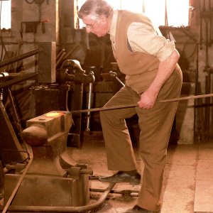 Stanley Lowis in his forge.  He worked for Caudwell Farms for many years as blacksmith.