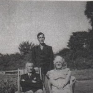 George Bancroft and Alice Burgess with their son, Raymond, standing behind them.