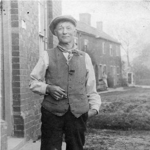 "Mash" Osbourne.
Bill Osbourne was one of several members of his family to carry the middle name "Massingberd". He is shown outside the White Horse Inn, with Drain Bridge Cottages, now demolished, in the background.