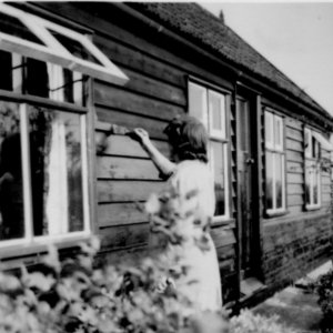 Nora Sargent painting thei wooden bungalow in Littlefield Lane.