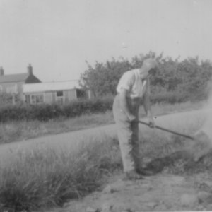 This picture shows Mr Percy Lyons having a bonfire.
In the background can be seen the shed in the School House garden and the Mill House with its orchard.