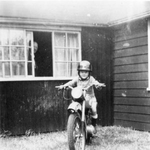Peter Leak on Charlie Oxborrows motorbike at the home of his uncle, Sam Oxborrow.
Sam lived in a wooden bungalow in Lowgate - now demolished.
Date of photograph c. early 1950s.