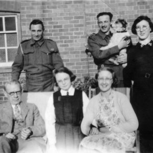 The names of the soldiers are unknown but the dog was called "Dinky".
The lady on the right is Joyce Cross and on the front row is Percy Lyons, Jean Lyons and Marion Lyons.
The photograph was probably taken at the School House in Septembber 1940.