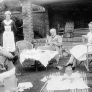 This photograph was taken in the garden of Norman Cottage
The people seated are visiting Mr and Mrs Jackson, the owners, and their son Julien can be seen lying on a shawl in the foreground
The photograph was taken 1937 or 1938.