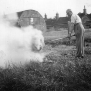 This picture shows Mr Percy Lyons opposite the School House in Mill Lane.
In the background can be seen the end of the old Village Hall which was a nissen hut.
C. late 1940s or early 1950s.