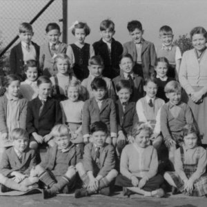 Photograph taken in Marshchapel School playground c. 1955.
Back row: Royce Lowis, Martin Smith, Ann Wilson, Peter Leak, Mick Hiscock, Keith Wray, Mrs Kathleen Williams - Teacher.
Next row: Geoff Newton, Patricia Alexander, Unknown, Wilfred Deamer, Ken Garner, Josephine Riggall.
Next row: Sheila Gigg, Joey Brooks, Jill Hibbert, Unknown, Renetje Parker, Philip Emmerson, Nigel Fisher.
Next row: Keith Peart, Jacky Worrell, Pete Smith, June Shephard, Sylvia Bartholemew.