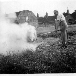 Percy Lyons who was the Headmaster of Marshchapel School.
He can be seen here tending a bonfire outside the School House in Mill Lane. 
The old Village Hall, which was a nissen hut, can be seen in the background.