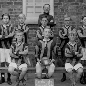 Marshchapel School Football Team. Although the date cannot be seen on the board in front of the team it is likely that this photograph was taken around 1928 or 1929.
The goalkeeper at the back is Albert Wilson and the Headmaster Percy Lyons.